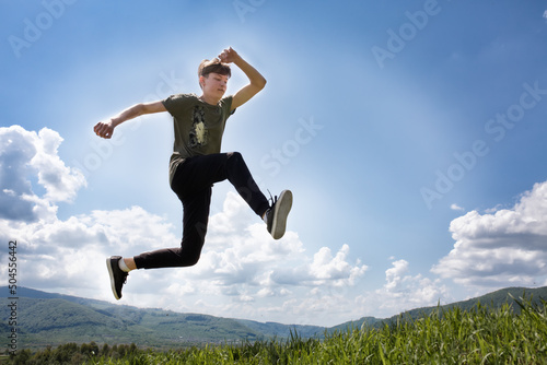 Sports guy in a jump. High jump in the mountains. Summer landscape. Ukrainian Carpathian mountains.