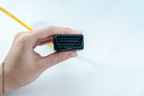 Yellow car diagnostic OBD2 cable in hand isolated photo