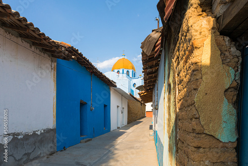 A blue church with its yellow dome and a clean blue sky photo