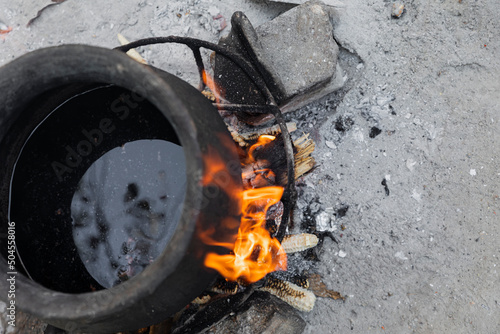 Closeup to the fire under a pot of black clay photo
