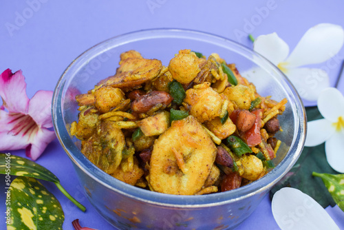 Farali bhelpuri made with faradi ingredients like banana chips, sago balls, mixture, tomato, capsicum on white background. Eaten during Fasting days like ekadashi, Mahashivratri . Blank space for text