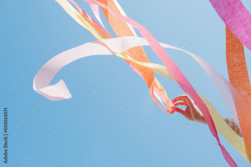 © jamie grill atlas/Stocksy - Cheerful Streamers against a Blue Sky