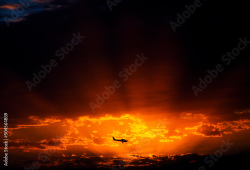 A small plane flies at sunset. photo