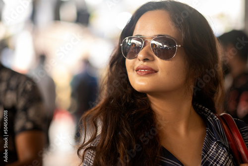 Portrait of a moder wearing sunglasses and standing in  street daytime photo