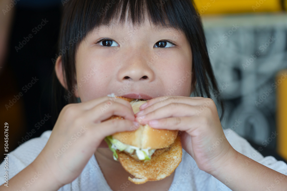 little girl eating hamburger