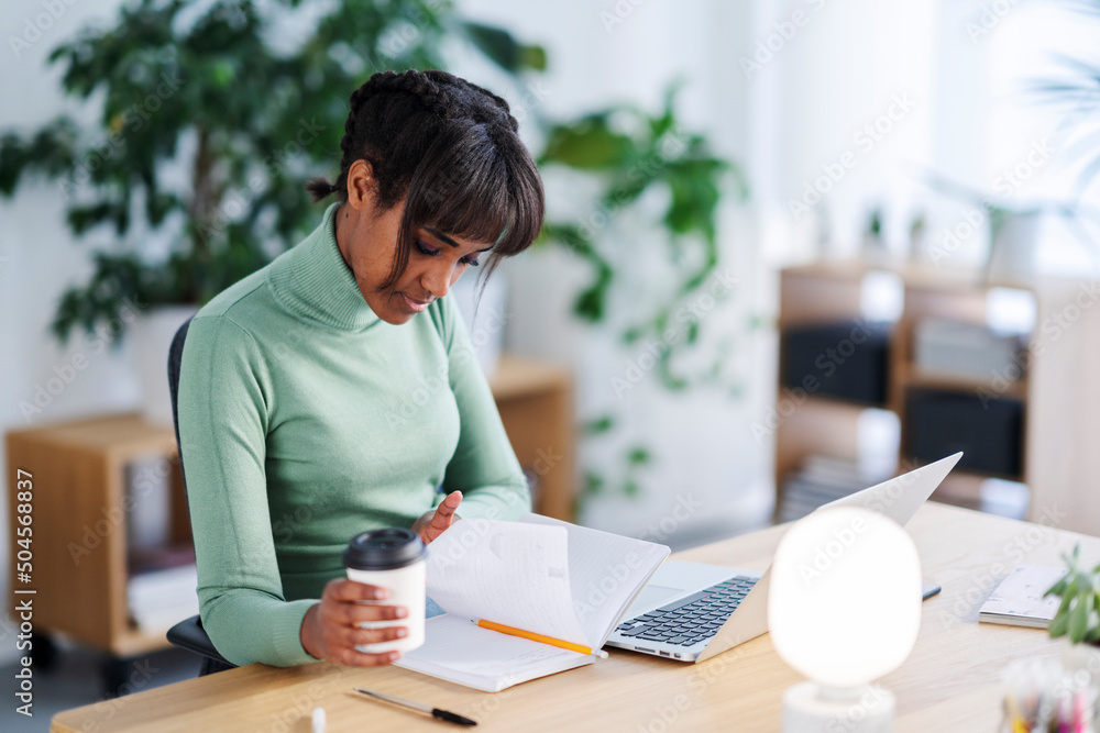 Black woman with coffee to go working at home Black woman with coffee to go working at home