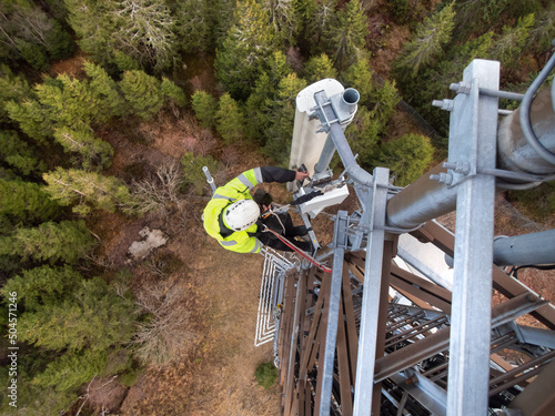 A technician on a telecommunication tower, 5G fiber optic antenna photo