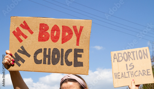 Protesters holding signs My Body My Choice and Abortion Is Healthcare. People with placards supporting abortion rights at protest rally demonstration. © Longfin Media
