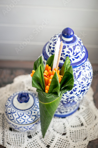 Orange trumpet, candle and incense sticks in banana leaf cones