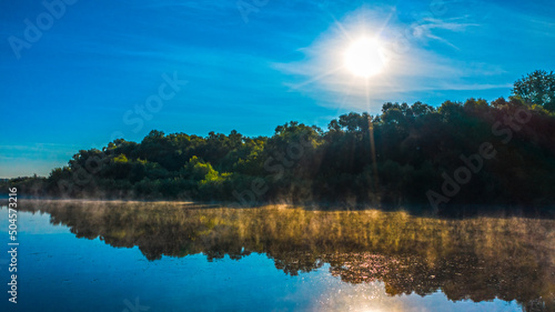 Aerial  view of a beautiful summer  landscape over river while dawn. Top view over river with a smooth water surface reflecting blue sky. Morning evaporation on a river while sunrise. photo