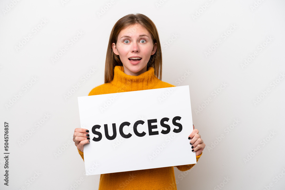 Young English woman isolated on white background holding a placard with text SUCCESS with surprised expression Young English woman isolated on white background holding a placard with text SUCCESS with surprised expression