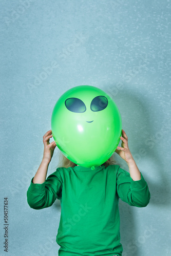 child dressed in green clothes playing alien Fototapeta
