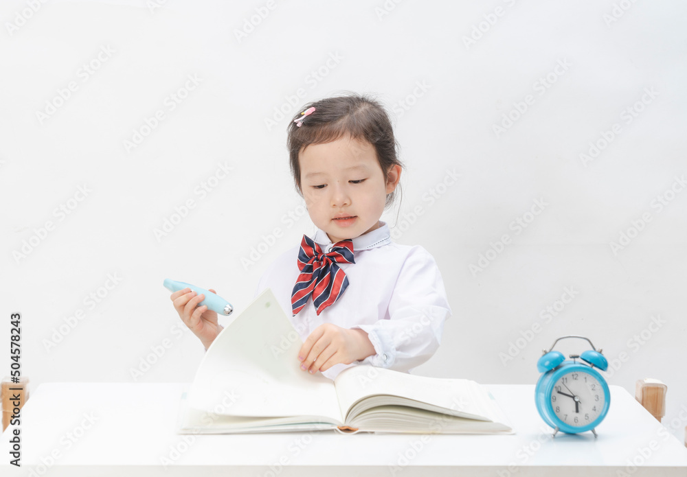 The little girl in school uniform is doing her homework The little girl in school uniform is doing her homework
