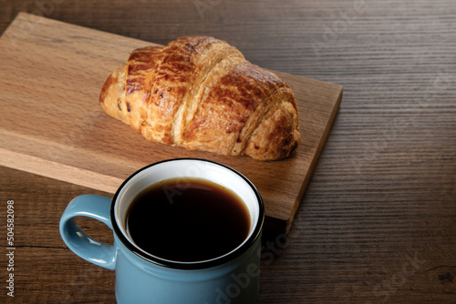 Fototapeta Naklejka Na Ścianę i Meble -  Croissant with a cup of full coffee, directly above