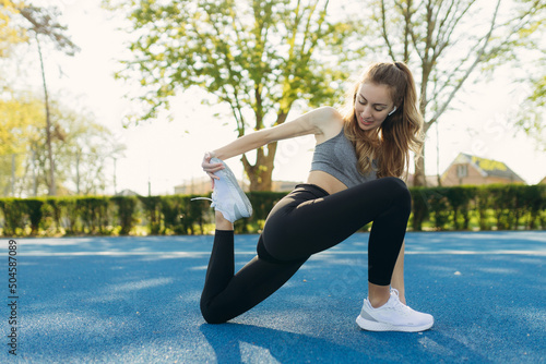 Pretty girl doing stretching before running in the stadium. Sports girl. The concept of a healthy lifestyle