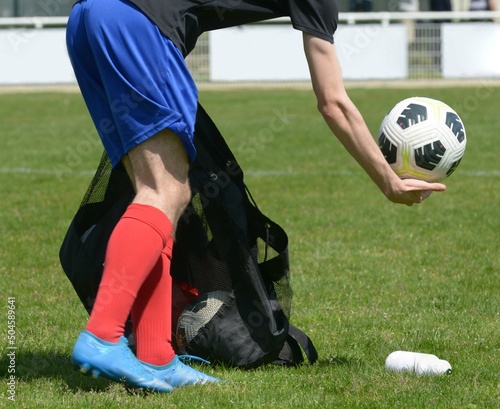 Fototapeta Naklejka Na Ścianę i Meble -  le joueur de football ramasse les ballons sur le terrain au football	