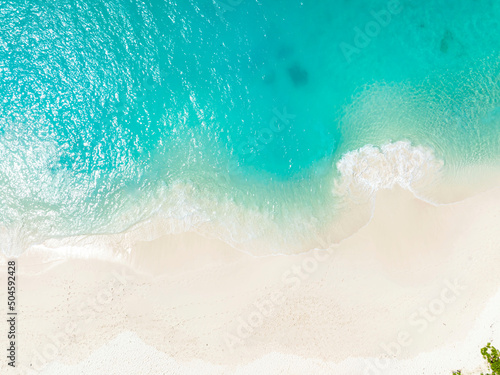Top view of Soft wave of blue ocean on sandy white beach. Background