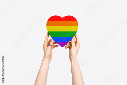 LGBT symbol. Rainbow heart in hands on white background top-down