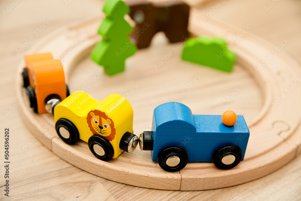 Fototapeta premium Wooden railway and train with animal wagons on wooden floor. Nostalgia toy from childhood.