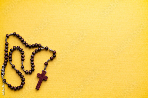Fotografie Rosary for prayer on a yellow background. catholic hail Christian