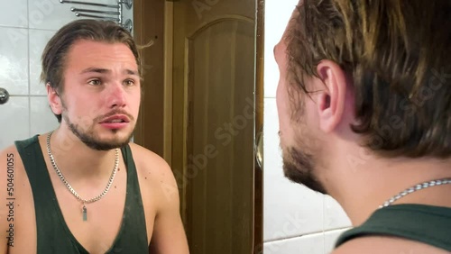 Adult man mad at himself and screaming in front of mirror, inner frustration photo