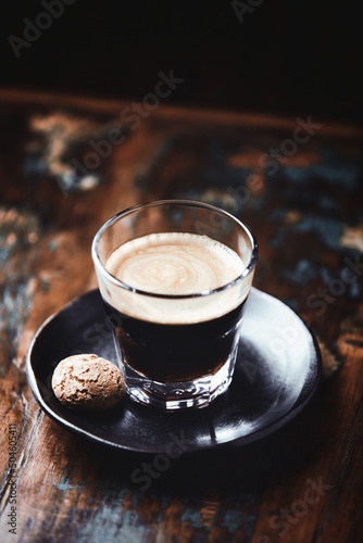 Fototapeta Naklejka Na Ścianę i Meble -  Coffee in glass cup on dark wooden background. Close up.