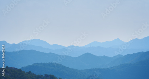 Mountain landscape with layers effects in blue haze © pridannikov