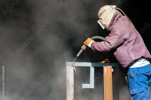 Sandblaster is sandblasting to steel material. Sand blasting is also known as abrasive blasting, which is a generic term for the process of smoothing, shaping and cleaning a hard surface by forcing. photo