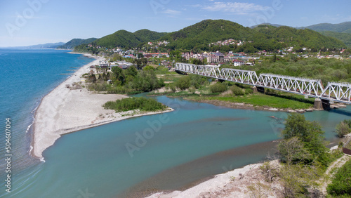 Aerial view of the railway bridge running along the sea coast. The confluence of the Shakhe river with the Black sea. Golovinka, Sochi, Russia. photo