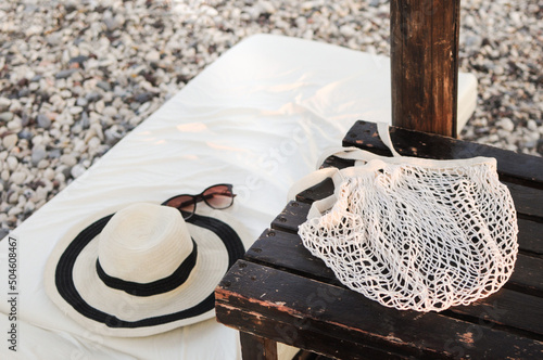 Summer accessories: straw hat, eco-friendly mesh shopping bag, and sunglasses photo