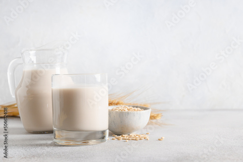 Barley milk in glass on light background. Alternative vegan lactose free milk. Copy space.