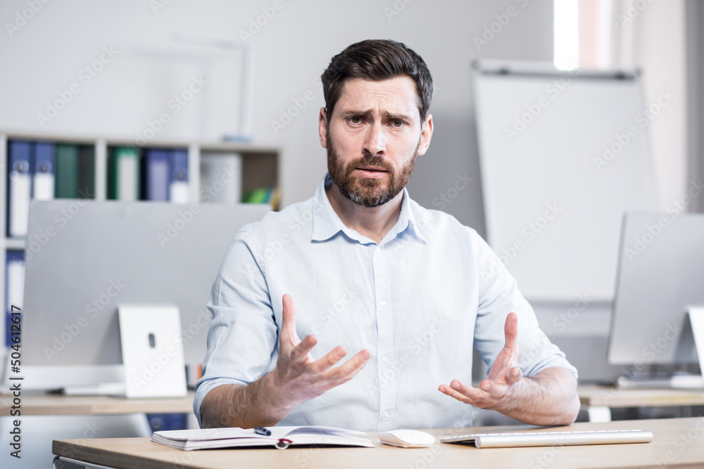 Angry and angry man looking at webcam talking on video call with colleagues online meeting