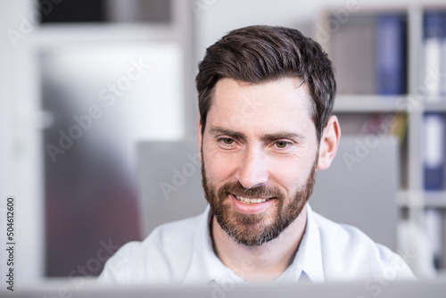 Close-up portrait of businessman at work looking at monitor working in office