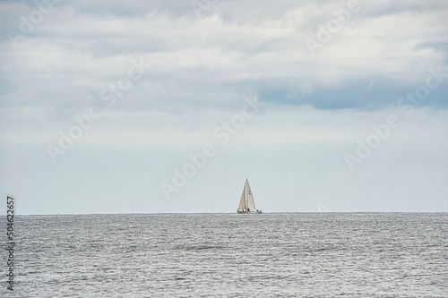 small sailing ship far away on the sea