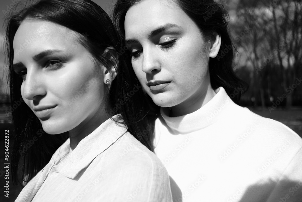 Black and white portrait of two girls. Girls in white dresses walking in the park Black and white portrait of two girls. Girls in white dresses walking in the park