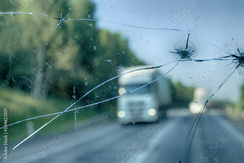 Highway through a broken windshield after encountering a truck with crushed stone. Challenging driving on Asian roads photo