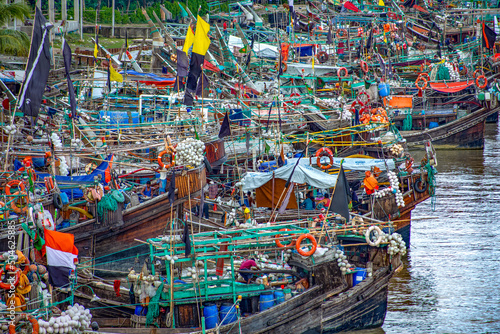 Fishing boats are arranged in river shore photo