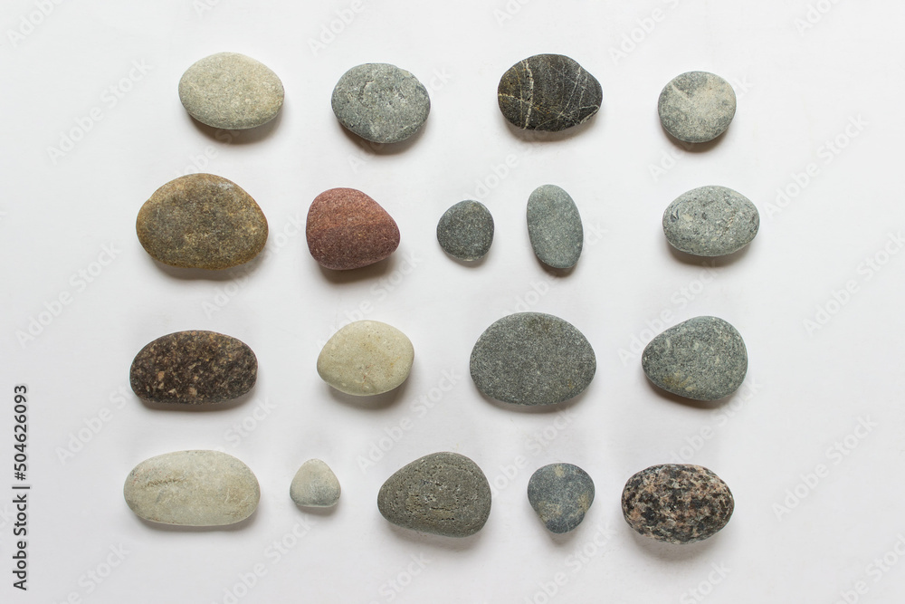 Collection of various small rounded stones on white background. Collection of various small rounded stones on white background.