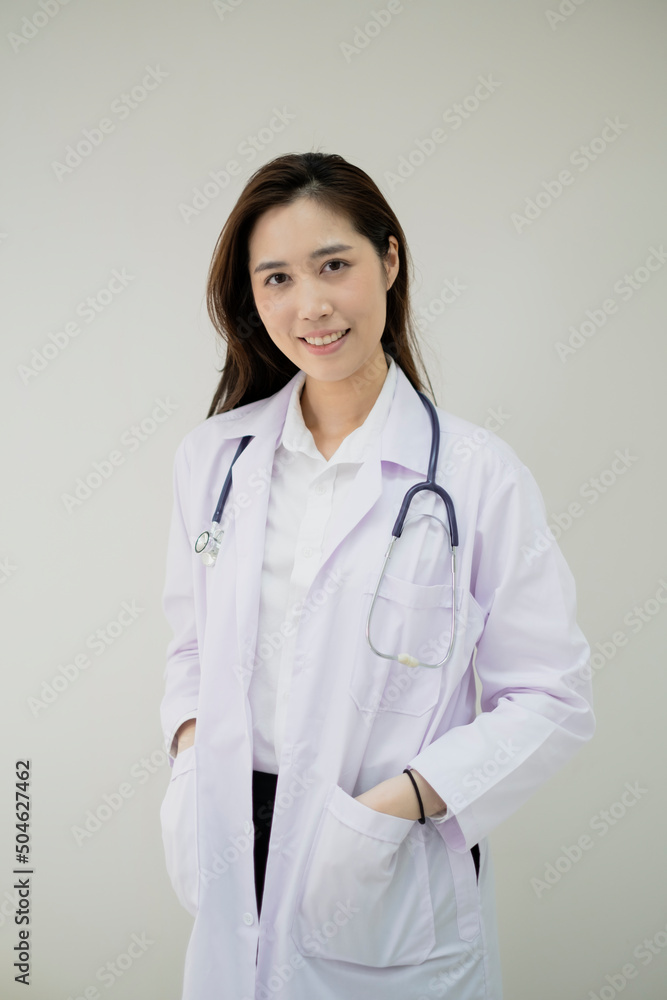 Smiling young woman Doctor is standing her office. Female Doctor with a stethoscope is standing in a clinic. Confident young adult female Doctor GP wear white coat and stethoscope. Smiling young woman Doctor is standing her office. Female Doctor with a stethoscope is standing in a clinic. Confident young adult female Doctor GP wear white coat and stethoscope.