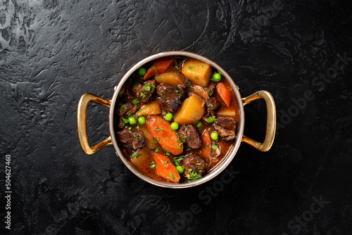 Irish stew made with beef, potatoes, carrots and herbs. Traditional St patrick's day dish. Black background, top view.