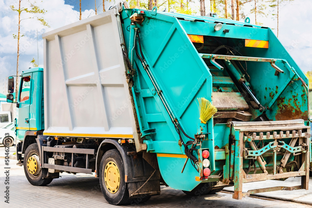 A garbage truck picks up garbage in a residential area. Loading mussar in containers into the