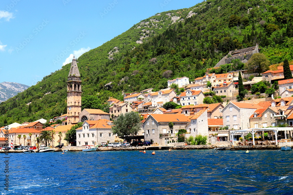 Boka Kotor Bay, Montenegro. Medieval city surrounded by high beautiful mountains, church, ancient tower. View from the sea.