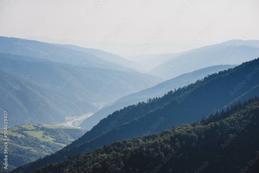 Amazing landscape in summer. Light and afternoon shadow over scenic mountain hills, clear blue sky. Mountain valley.
