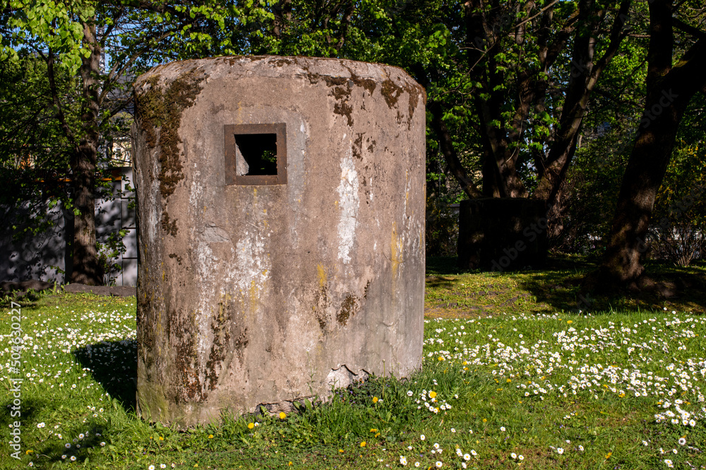 Air duct of a bomb shelter in the center of Kaliningrad. Military buildings in a sunny flower meadow
