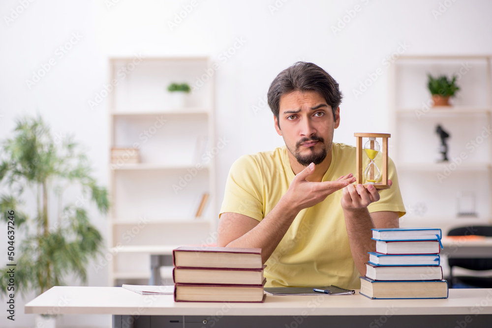 Young male student preparing for exams in time management concep Young male student preparing for exams in time management concep