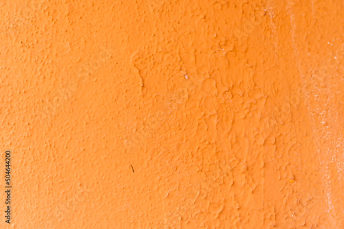 Orange wall texture with reliefs. Closeup. Orange background