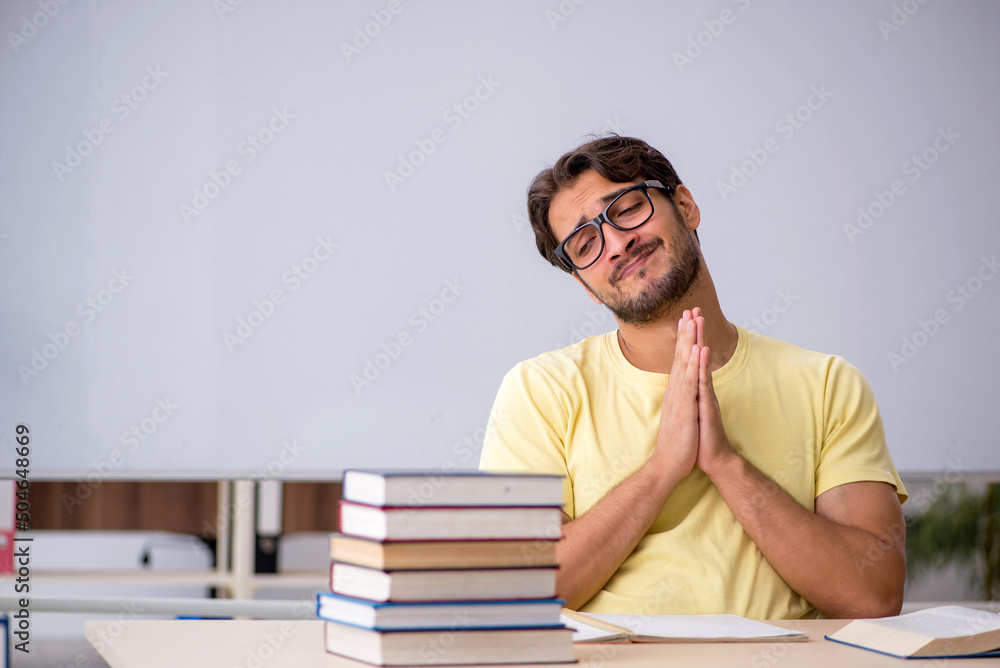 Young male student preparing for exams in the classroom Young male student preparing for exams in the classroom