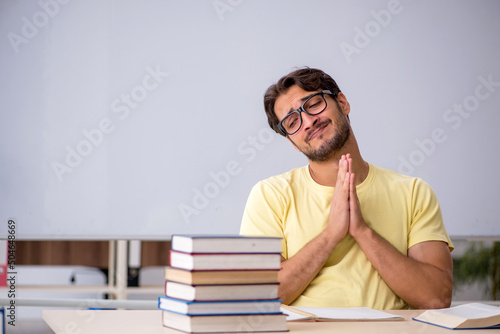 Young male student preparing for exams in the classroom