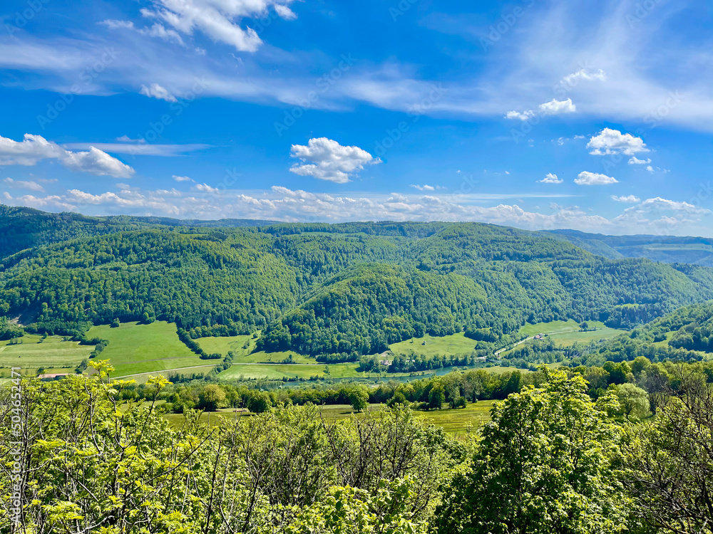Panorama from the Swiss village of Réclère over the Doubs valley, its mountains and its forests, on a sunny summer day