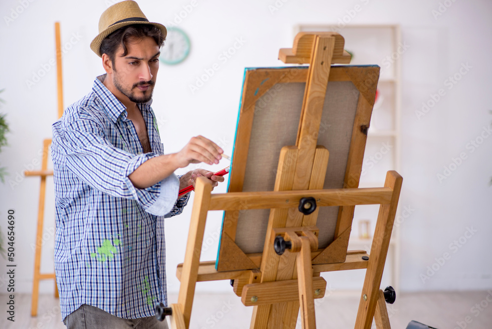 Young man enjoying painting at the studio Young man enjoying painting at the studio